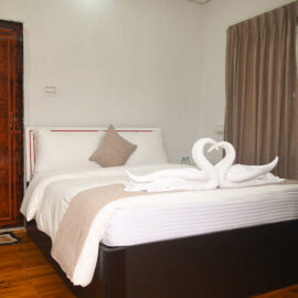 Spacious garden-facing cottage room at Ishani Resort Diamond Harbour with elegant décor and cozy bedding